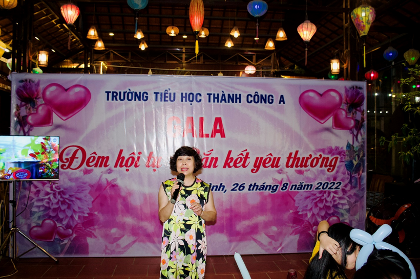 A person standing in front of a large banner

Description automatically generated with low confidence
