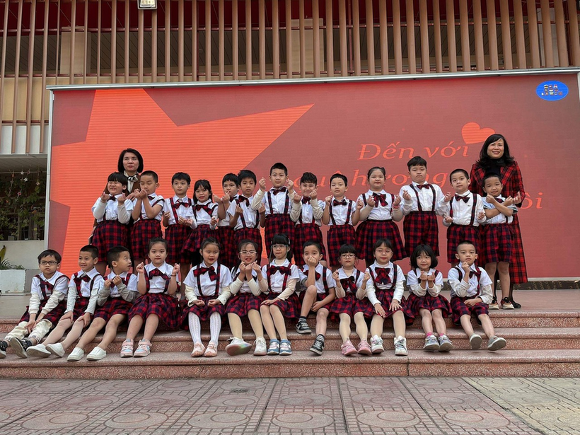 A group of people posing for a photo in front of a red wall

Description automatically generated with medium confidence