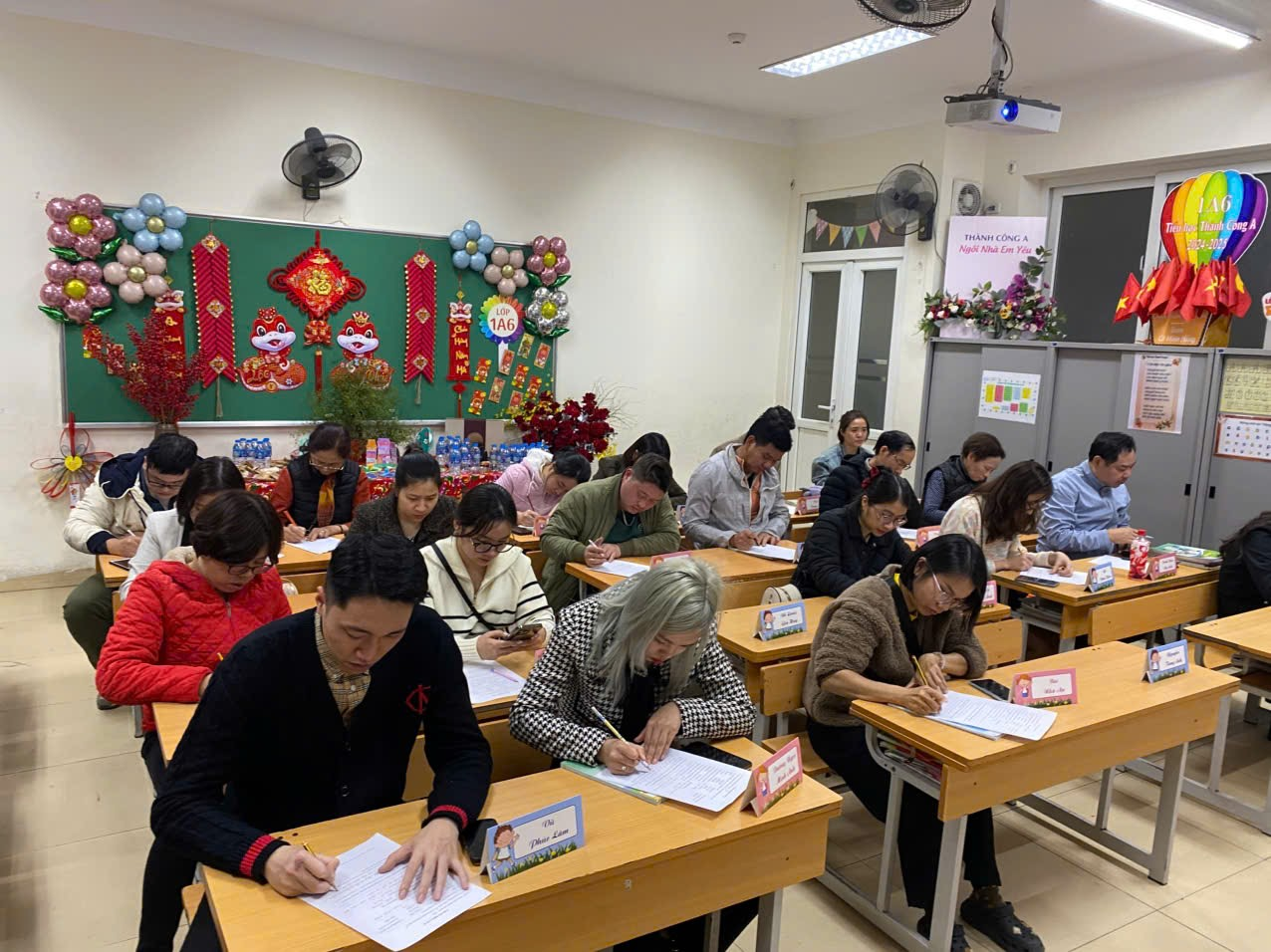 A group of people sitting at desks in a classroom

Description automatically generated