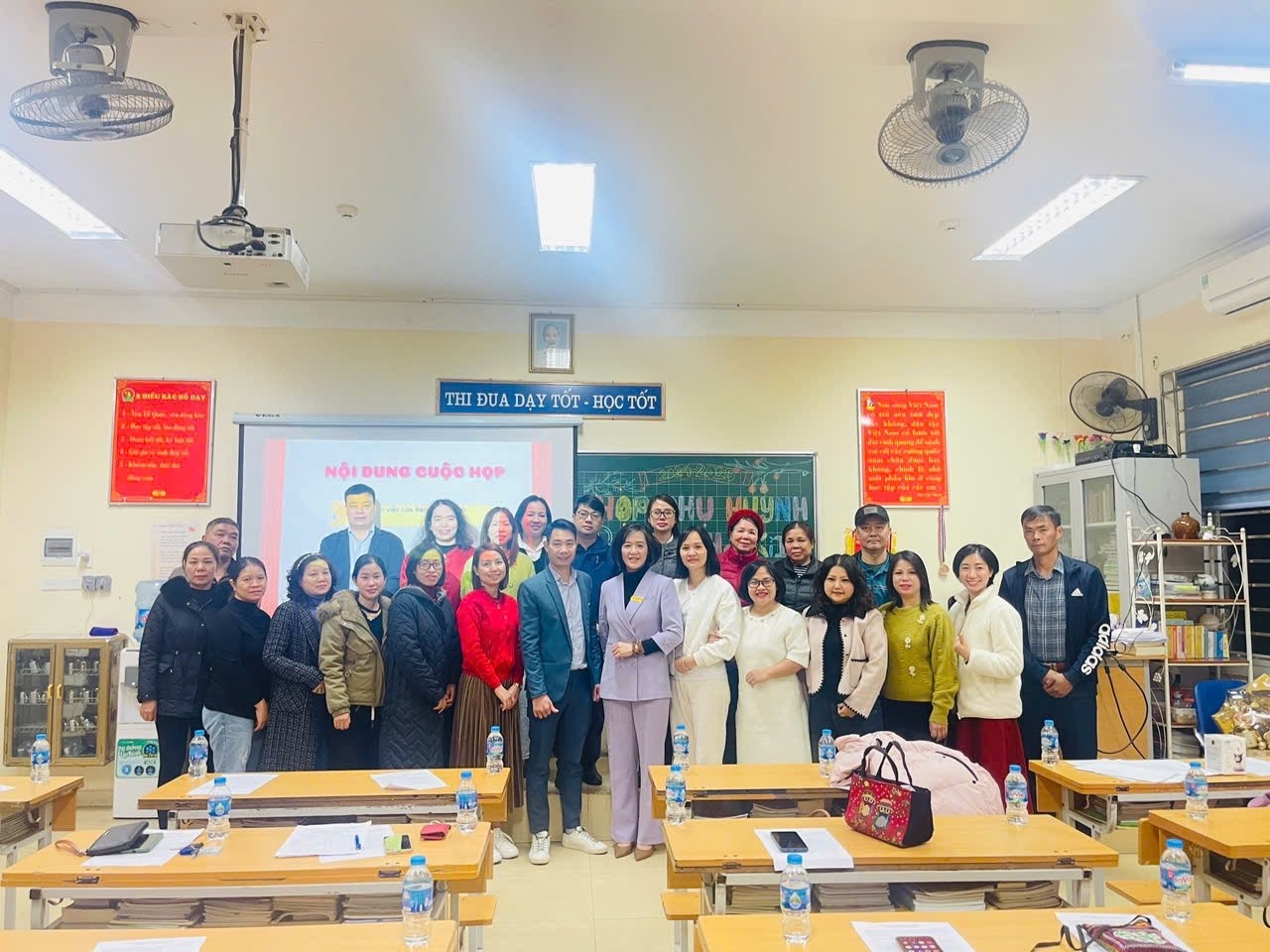 A group of people standing in a classroom

Description automatically generated