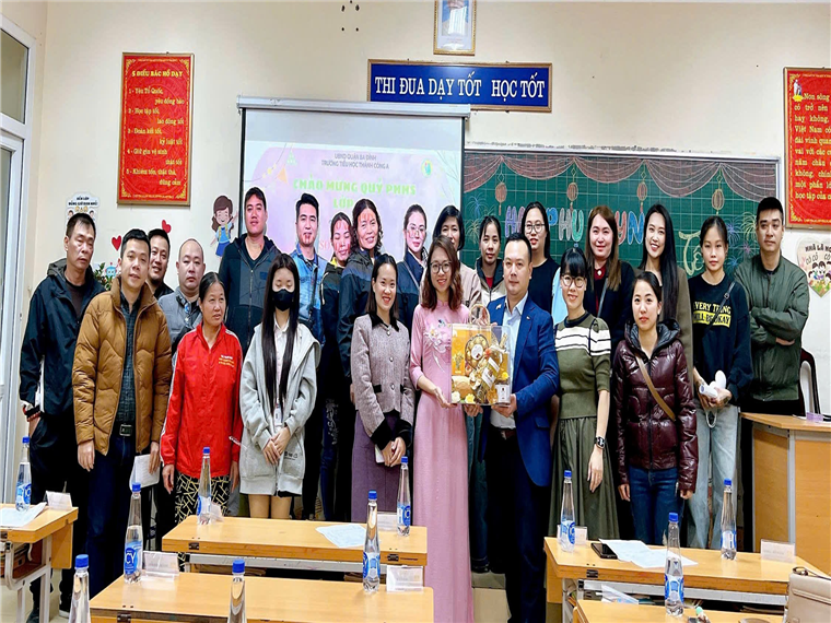 A group of people standing in a classroom

Description automatically generated