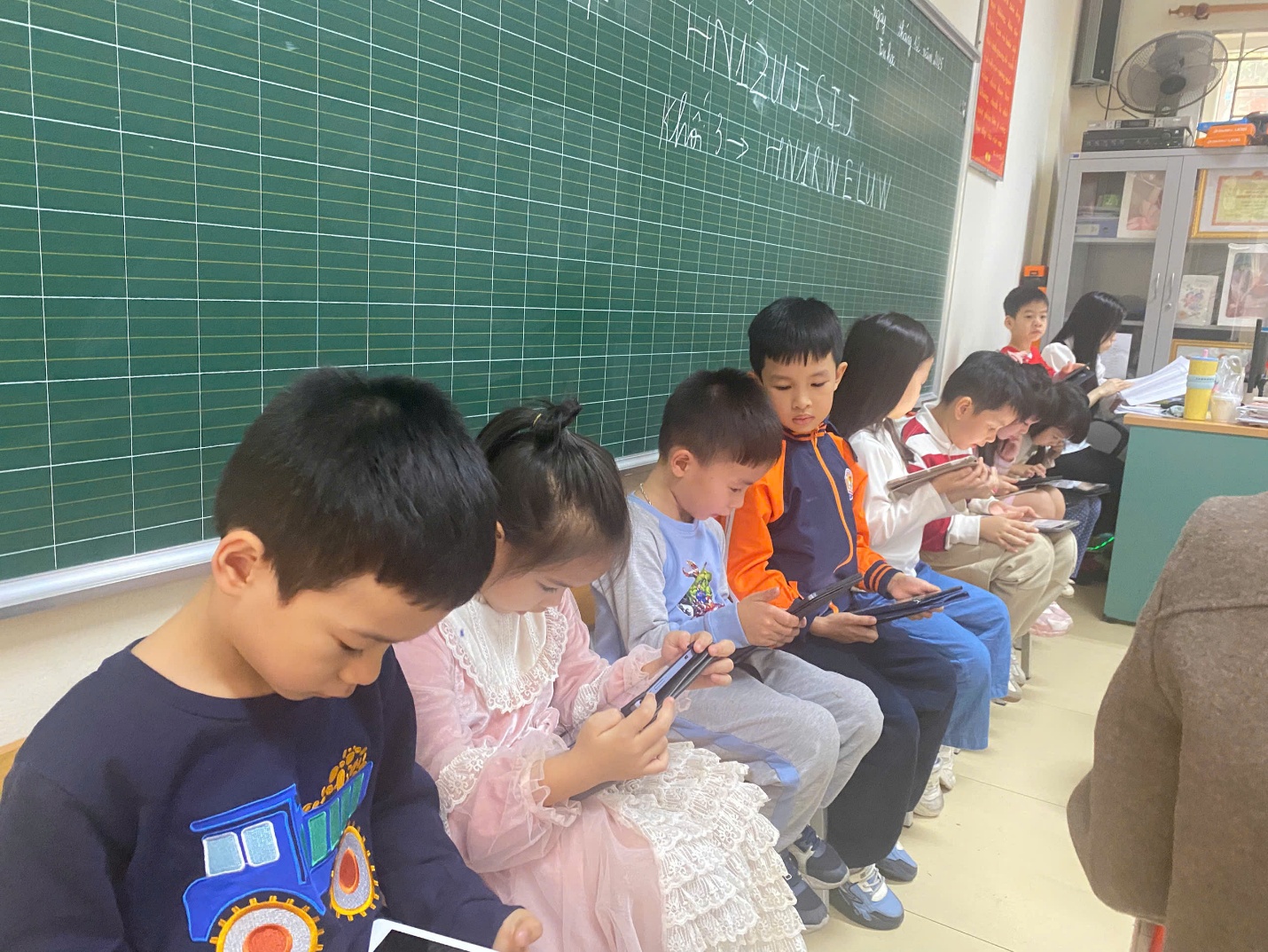 A group of children sitting in a classroom using their phones
AI-generated content may be incorrect.