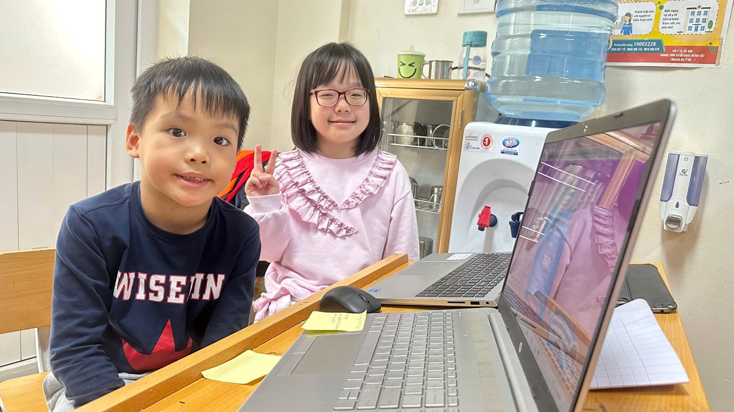 A child and child sitting at a table with a computer
AI-generated content may be incorrect.