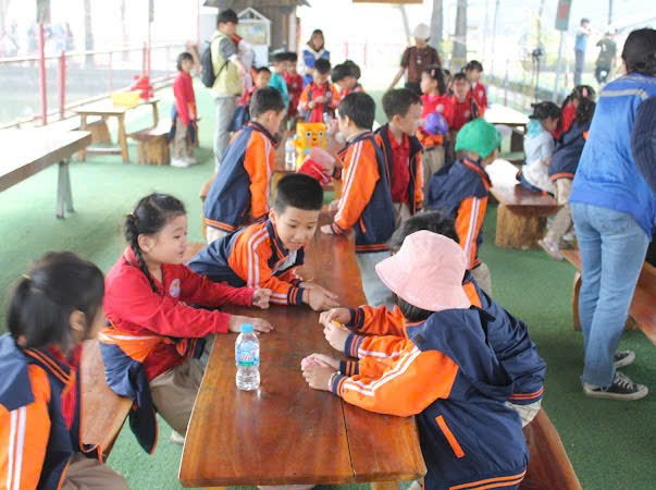 A group of children sitting at a table
AI-generated content may be incorrect.