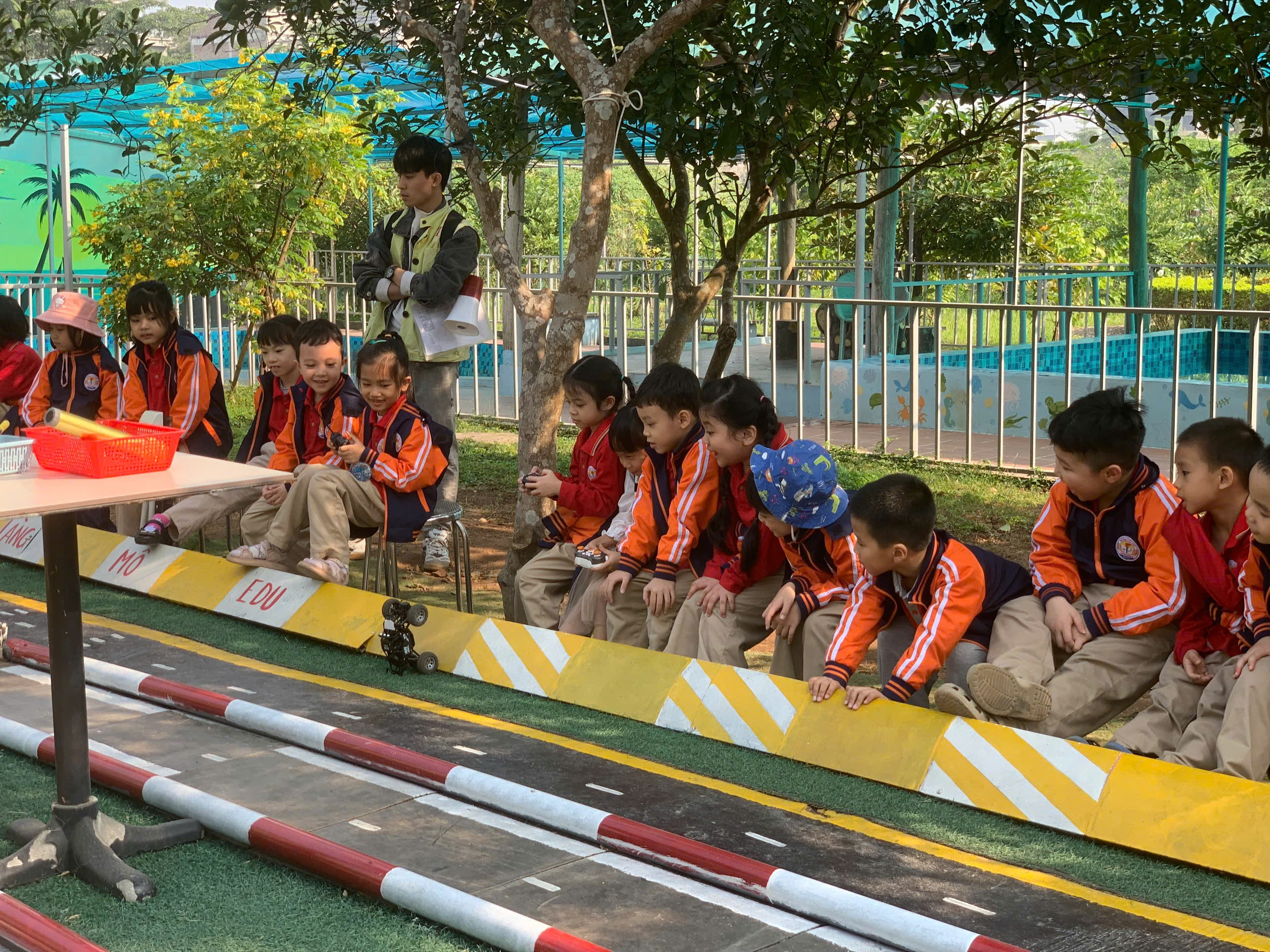 A group of children sitting on a race track
AI-generated content may be incorrect.