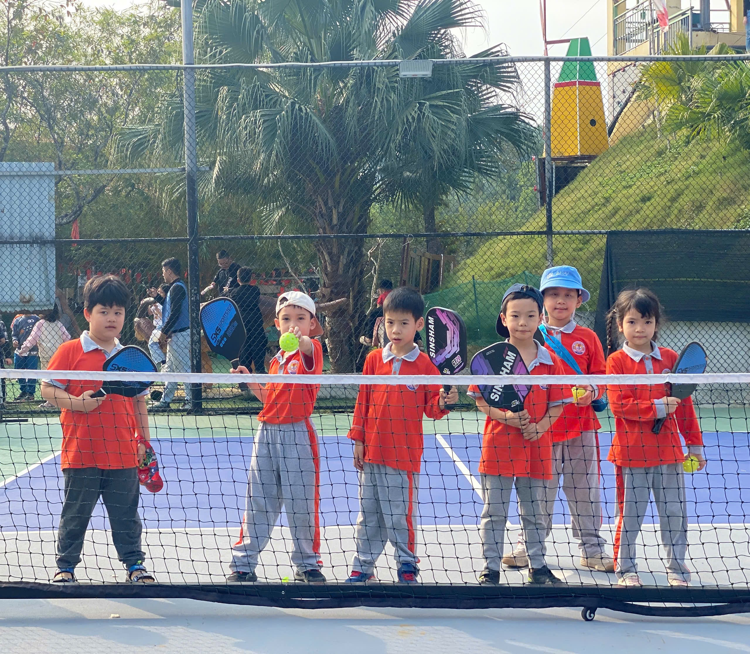 A group of kids standing on a tennis court
AI-generated content may be incorrect.