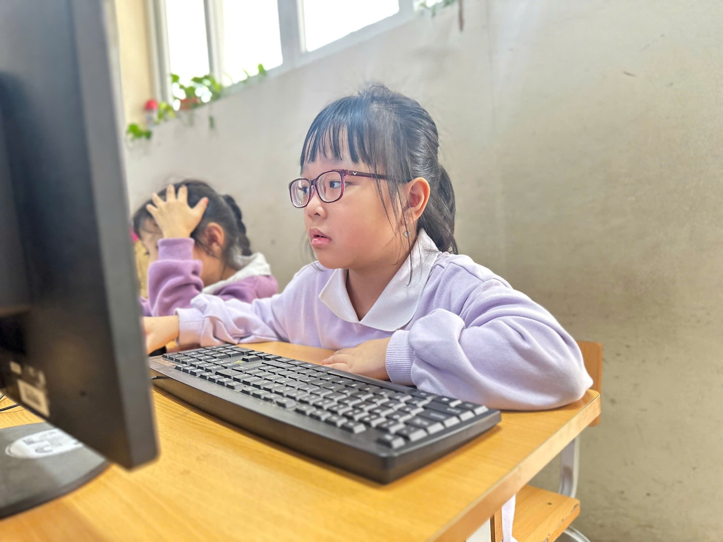 A child sitting at a desk with a computer

AI-generated content may be incorrect.