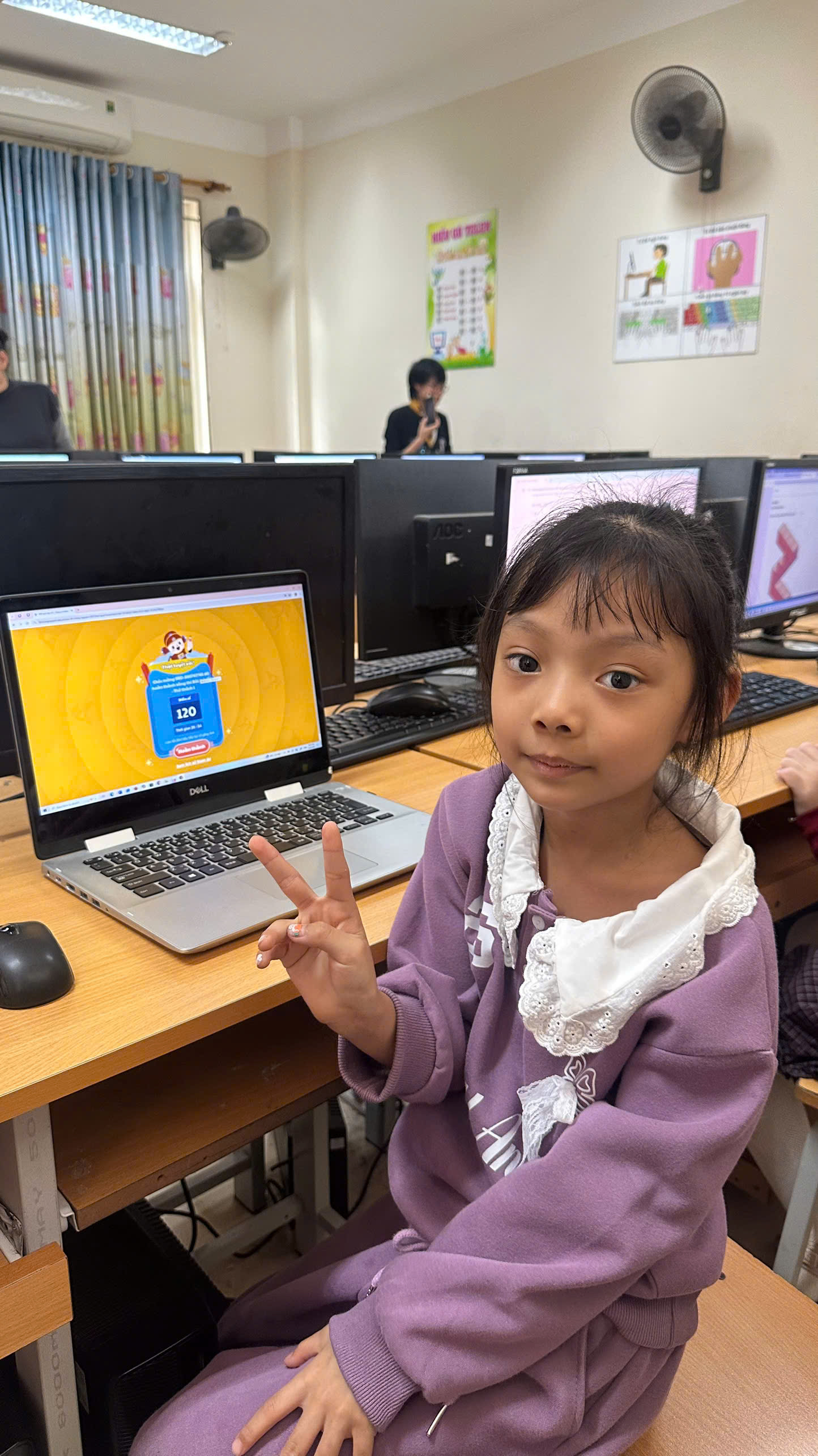A child sitting at a desk with a computer and a computer

AI-generated content may be incorrect.