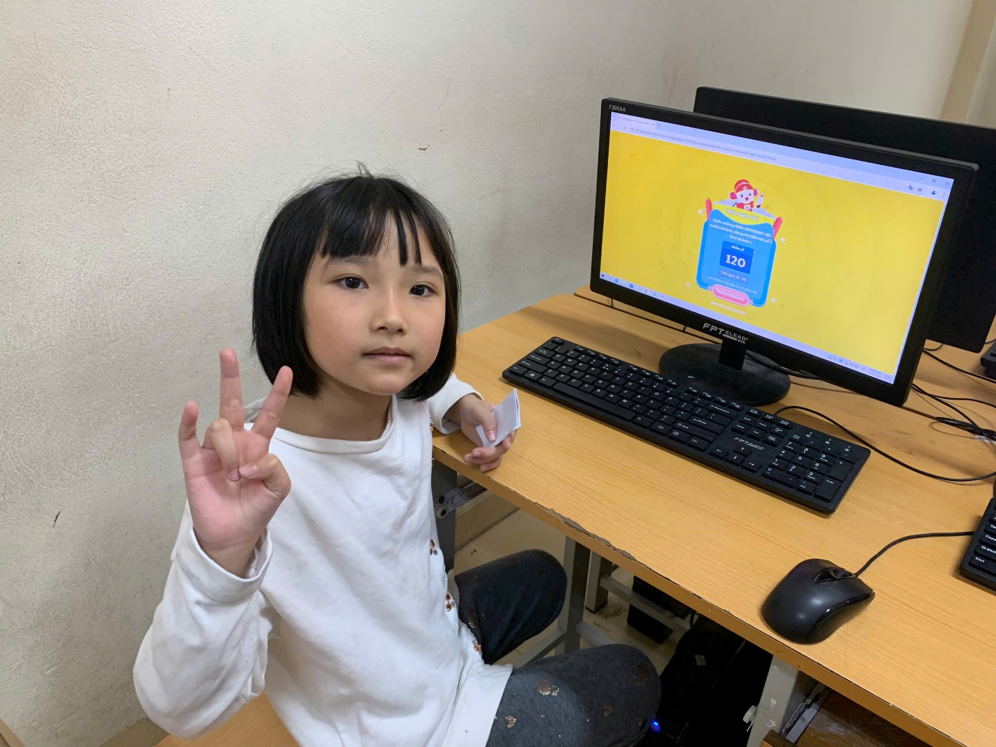 A child sitting at a desk with a computer and a peace sign

AI-generated content may be incorrect.