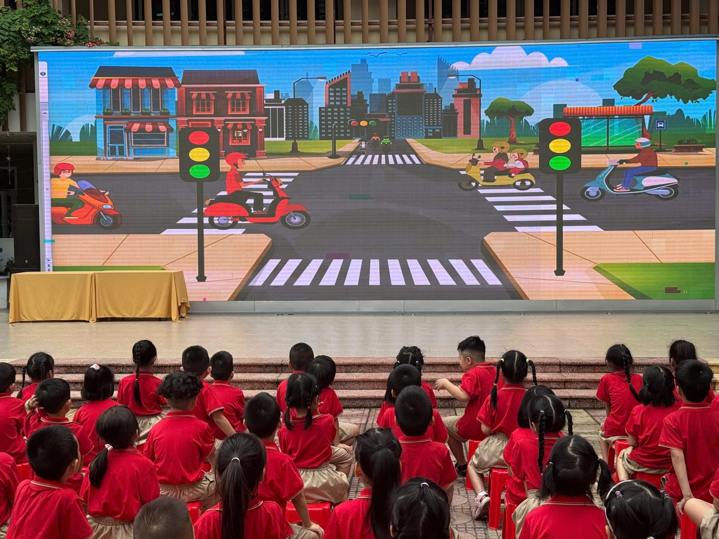 A group of children sitting on steps in front of a screen
AI-generated content may be incorrect.