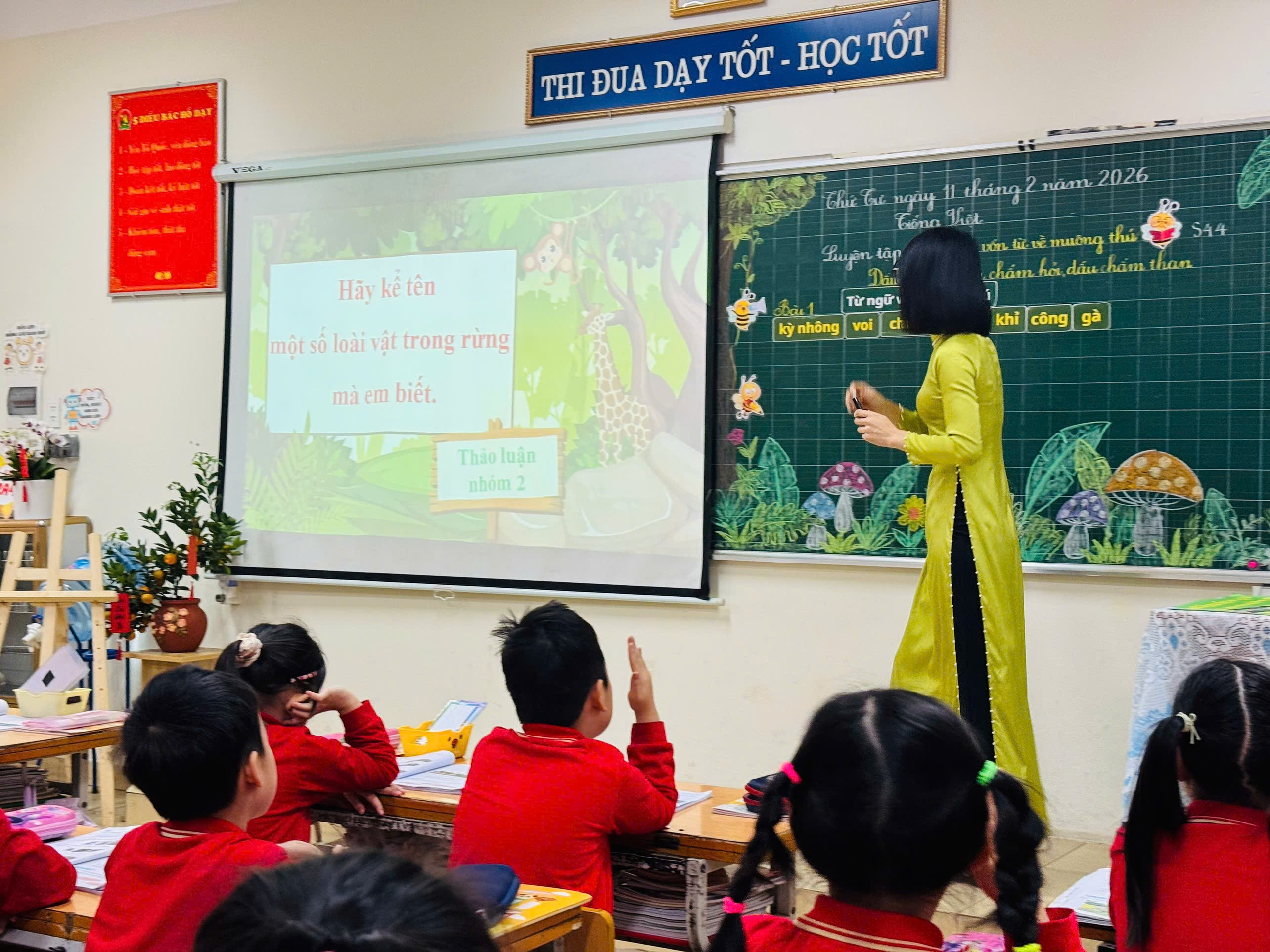 A person standing in front of a classroom with a group of kids raising their hands
AI-generated content may be incorrect.