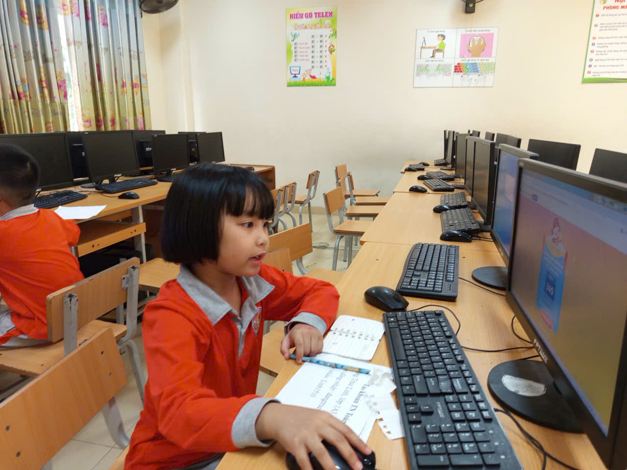 A young child sitting at a desk with computers

AI-generated content may be incorrect.